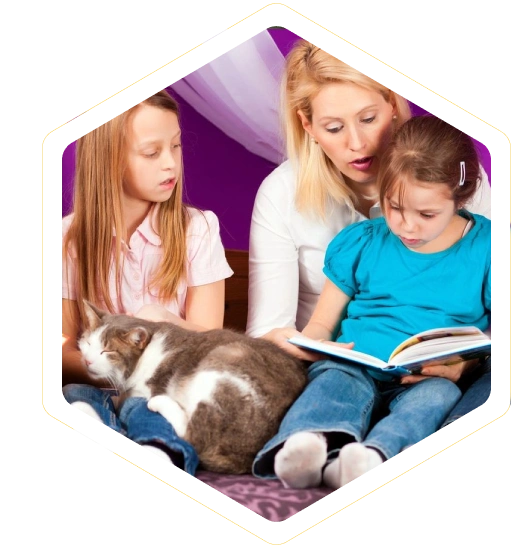 A mother reading a book to her two daughters with a cat.